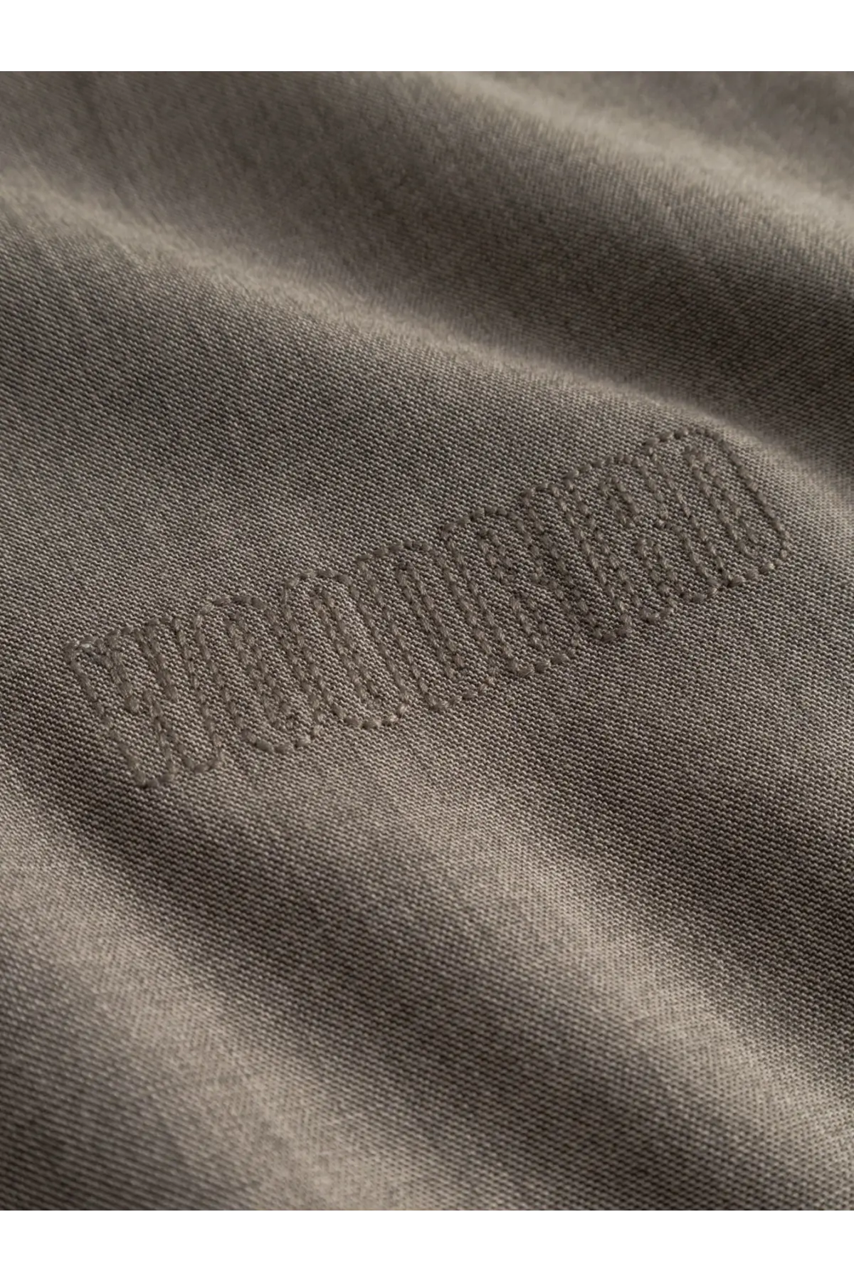 Close-up of dark olive green cotton t-shirt with tonal squad embroidery paired with woodbird men’s wbpon beige jacket in viscose blend