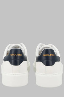 Woolrich men’s classic court sneaker in white wool with navy blue heel tabs and gold lettering shown from the back