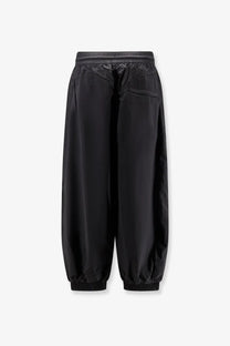 Black y-3 men’s baggy nylon trousers featuring sleek minimalist design with smooth lightweight fabric