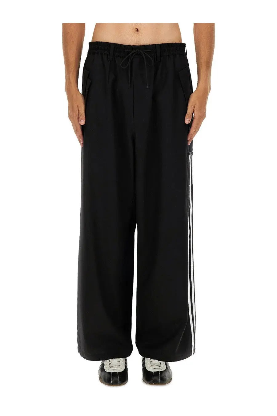 Black y-3 men’s jogger pants with wide-leg fit and three white stripes down the side for casual wear