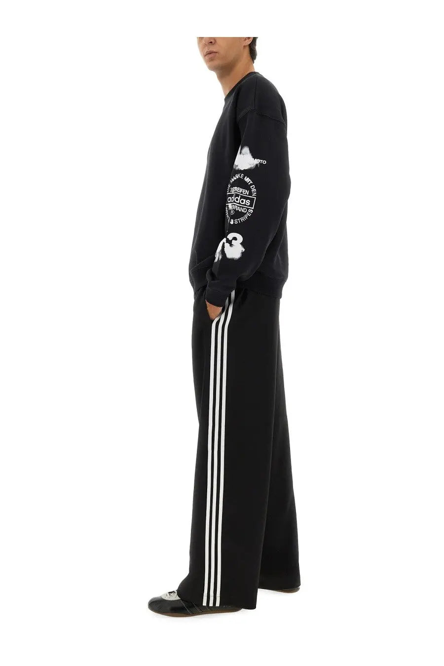 Black adidas y-3 men’s sport uniform stripes pants with white side stripes and graphic print on the sleeve