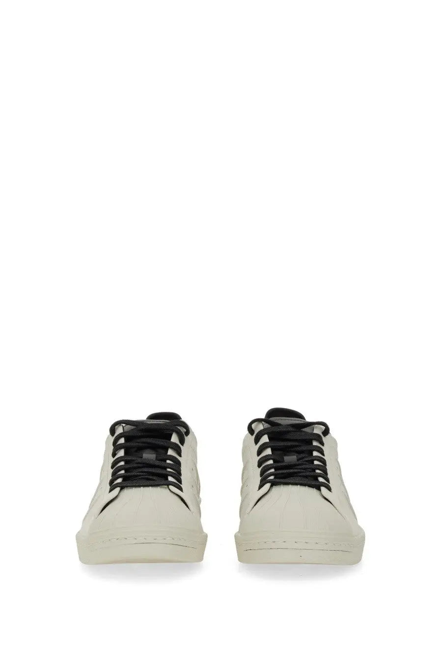 Cream-colored suede y-3 men’s superstar sneaker with black laces and minimalist low-top design in white