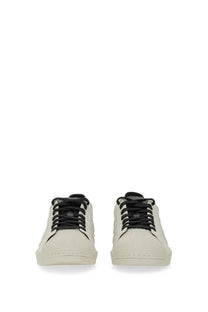 Cream-colored suede y-3 men’s superstar sneaker with black laces and minimalist low-top design in white