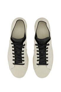 White leather y-3 men’s superstar sneaker with black laces and tongue in a classic low-top design