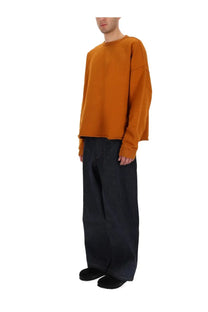 A loose-fitting burnt orange cotton sweatshirt with crew neck and frayed cuffs paired with ymc men’s replacement jeans blue
