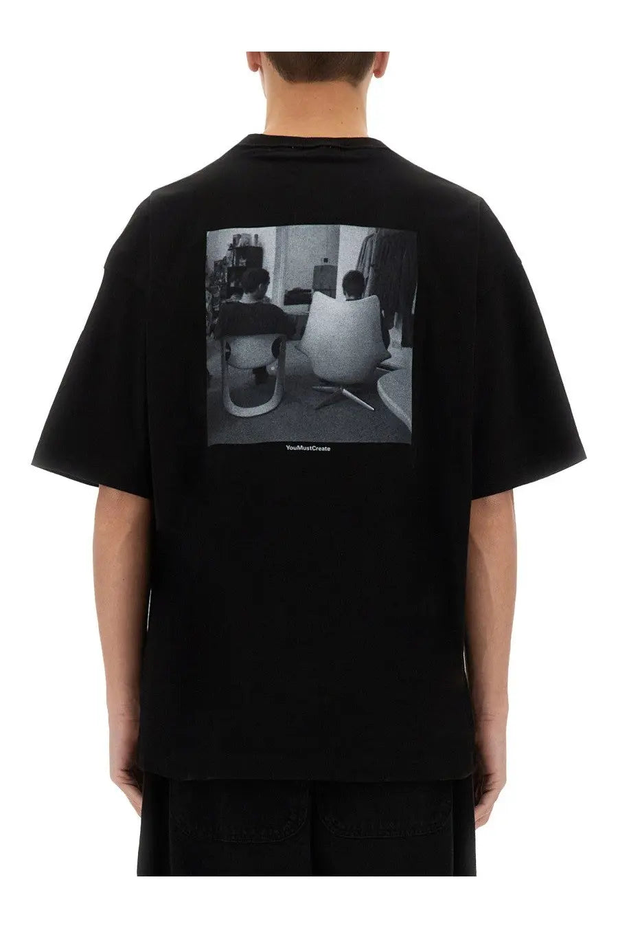 Back of black ymc men’s triple jc fm oversized t-shirt with black and white photographic print of two people in chairs
