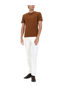 A slim fit brown cotton t-shirt with a subtle logo paired with zegna mens jeans roccia white