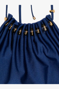 Deep blue satin drawstring bag with gold-tone metal hardware accents paired with zimmermann aster darkcobalt swimsuit
