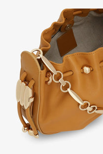 Zimmermann women’s halcyon leather clutch black shown with tan leather bucket bag featuring gold-tone chain strap and hardware