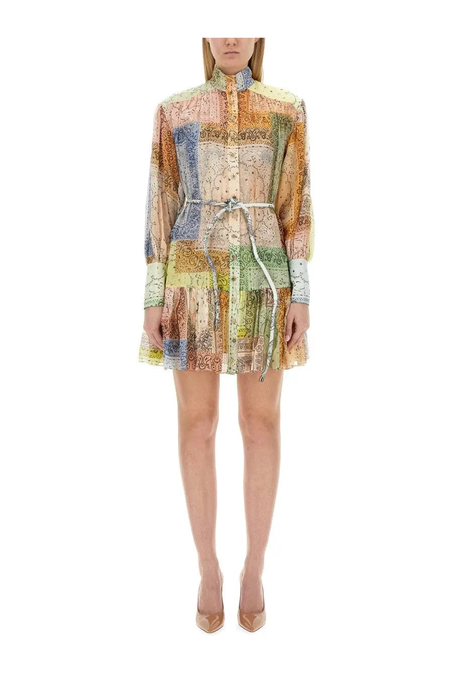 A woman wearing a Zimmermann women’s mini dress with long sleeves and vintage map patchwork in soft pastel tones