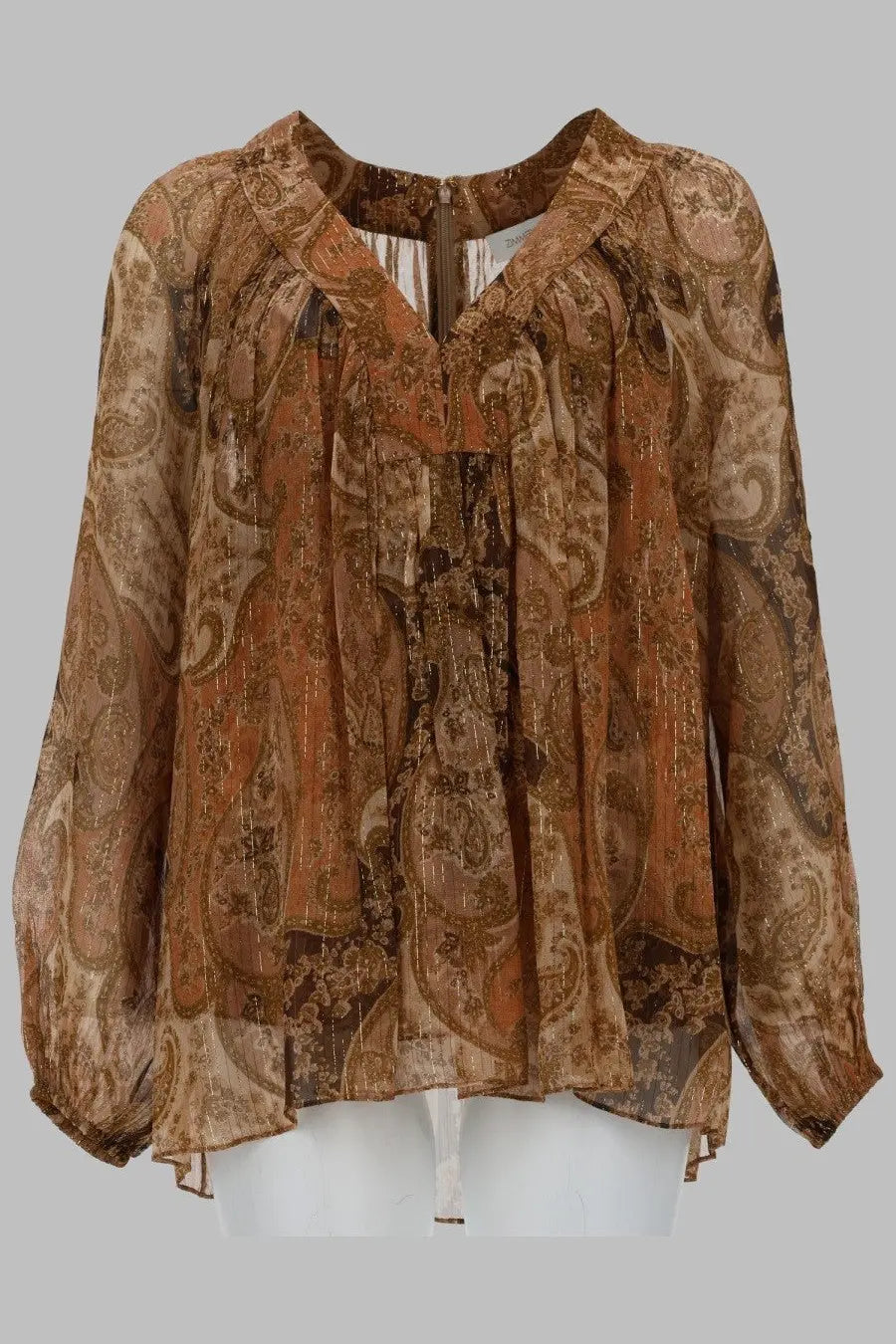A flowing, long-sleeved blouse in a rich brown and gold paisley pattern with sheer fabric.